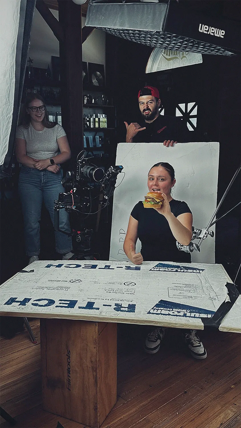 Behind-the-scenes crew adjusting lighting during brand video shoot