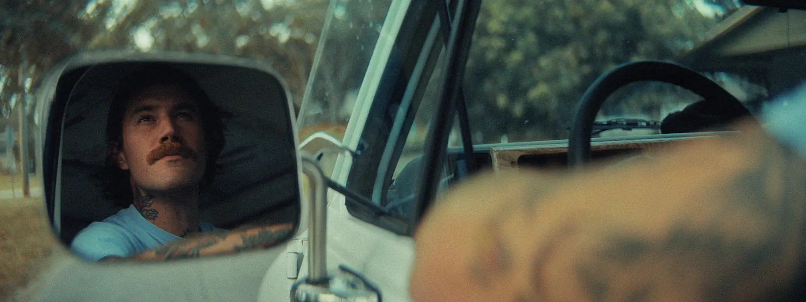Detail shot of St. Pete Sign Patiner driving to a job looking through mirror.