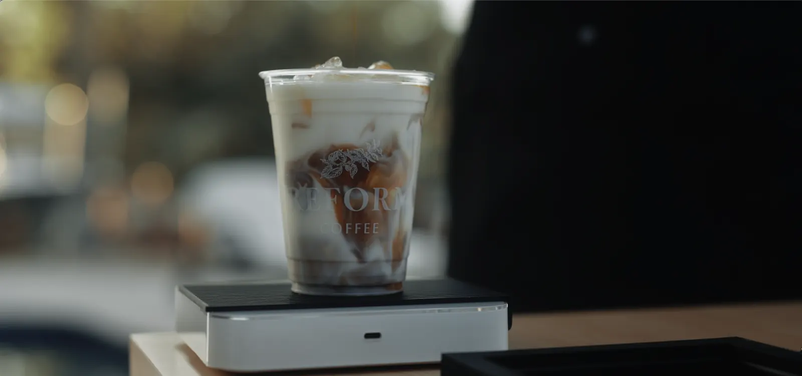 Layered iced coffee with CORE logo on a device