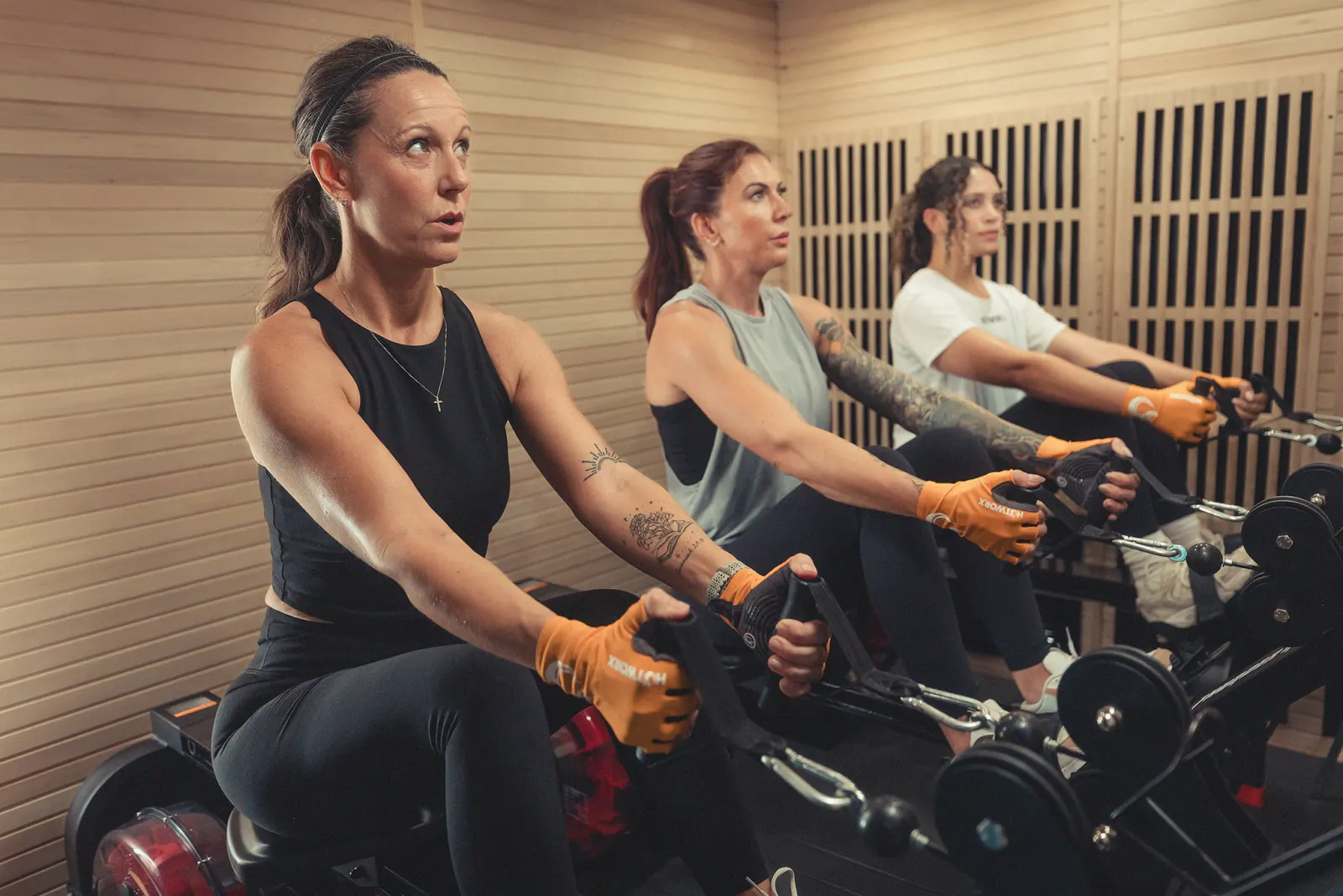 Three women rowing in a HotWorx infrared sauna